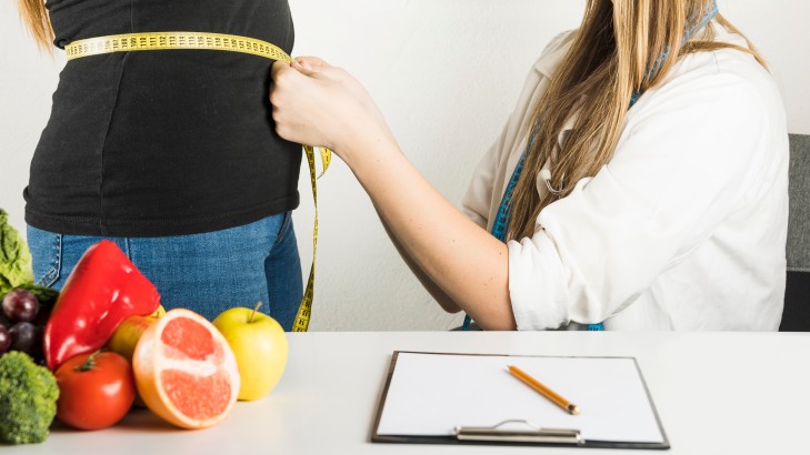 female dietician examining patient clinic 1